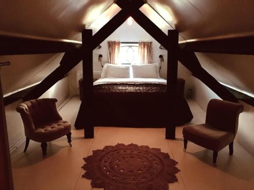 Stolwijk的住宿－De Beijersche Stee , Landhuysje，一间卧室配有一张床、两把椅子和一个窗户