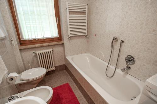 La salle de bains est pourvue de toilettes, d'une baignoire et d'un lavabo. dans l'établissement Apartment ARGENTIS Krumas-Living - Kronplatz, à San Vigilio Di Marebbe