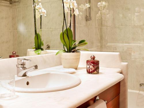 een badkamer met een wastafel en een spiegel bij Grecotel-LUXME Daphnila Bay Dassia in Dassia