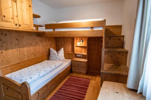 een slaapkamer met 2 stapelbedden en een ladder bij Apartment ARGENTIS Krumas-Living - Kronplatz in San Vigilio Di Marebbe