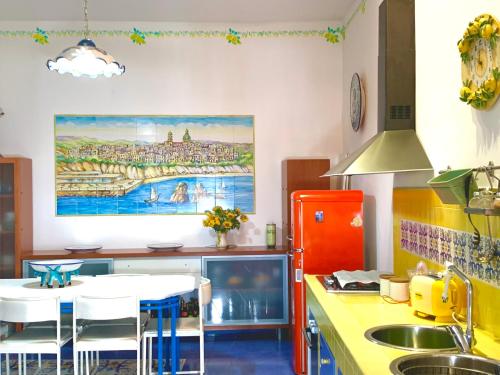 een keuken met een tafel en stoelen en een schilderij aan de muur bij La Finestra sul Duomo, Amalfi Coast in Vietri