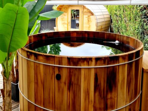 a wooden barrel with a bird bath in a garden at La Dame de Coeur la maison à l'orée de Deauville in Touques