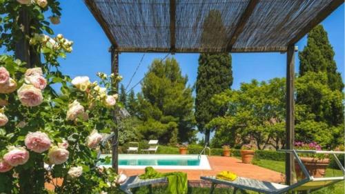 a garden with a swimming pool and flowers at Podere contignano in Contignano