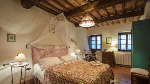 a bedroom with a large bed and two windows at Podere contignano in Contignano
