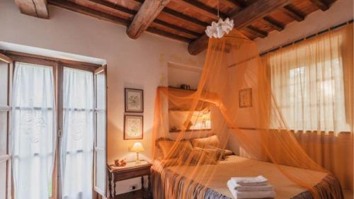 a bedroom with a bed with a mosquito net at Podere contignano in Contignano
