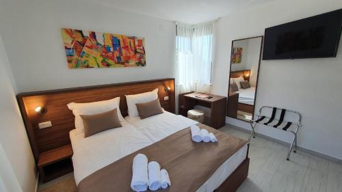 a bedroom with a bed with white slippers on it at Villa Ivan in Sveti Filip i Jakov