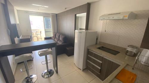 una pequeña cocina con nevera y mesa en Flat Brookfield Towers 2414 en Goiânia