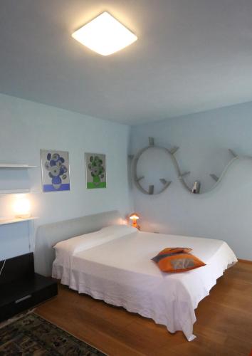 a bedroom with a large white bed and a light at A Casa di Maria in Grinzane Cavour