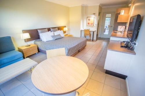 a hotel room with a bed and a table at Spinifex Motel and Serviced Apartments in Mount Isa
