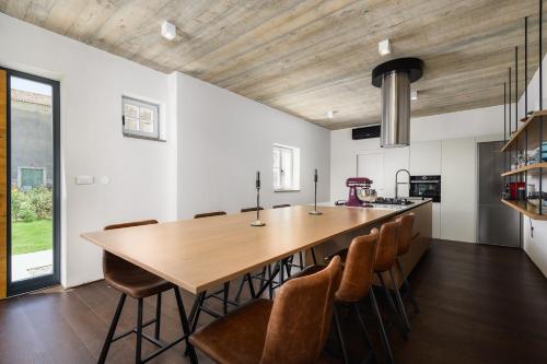 a kitchen with a large wooden table and chairs at Villa Volare Cantare with 2 br, a heated pool and panoramic view near Buje, Istra in Momjan