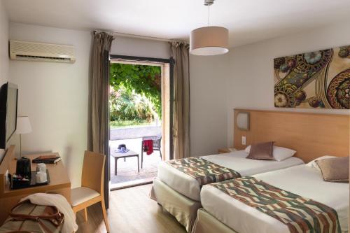 a hotel room with two beds and a window at Hotel U Ricordu & Spa in Macinaggio