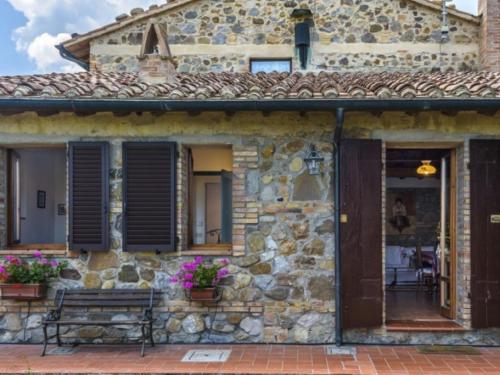a stone house with a bench in front of it at Podere del mezzadro in Contignano