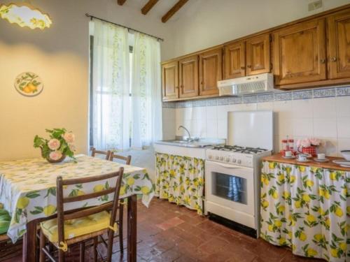 a kitchen with a stove and a table with a table cloth at Podere del mezzadro in Contignano