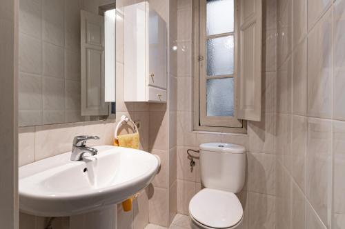a white bathroom with a sink and a toilet at Precioso y cómodo piso en Llanes a 5 de la playa Mercaderes in Llanes