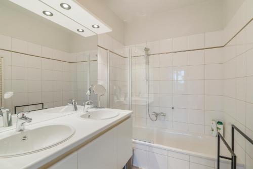 La salle de bains est pourvue de 2 lavabos, d'une douche et d'une baignoire. dans l'établissement Villa Francois, à Nieuport