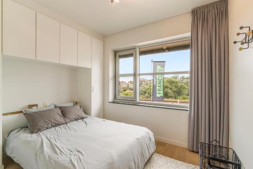 une chambre avec un lit et une fenêtre dans l'établissement Villa Francois, à Nieuport