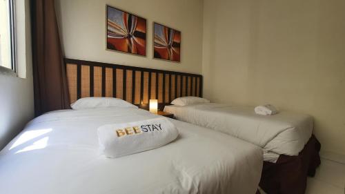 two beds in a hotel room with a sign on them at Gold Coast Morib Studio l Apartment I Penthouse in Banting