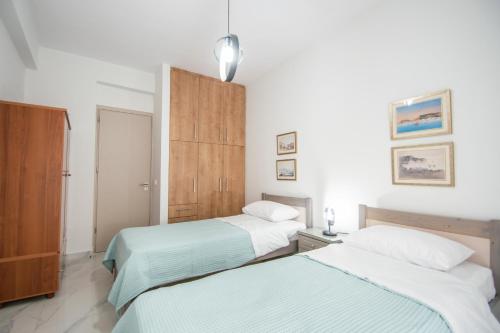 a bedroom with two beds and a cabinet at Jiji Riji Zante Apt in Zakynthos