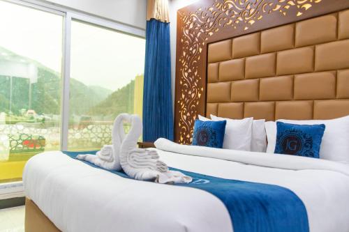 two beds in a hotel room with two stuffed animals at Jovial Gold Naran in Nārān