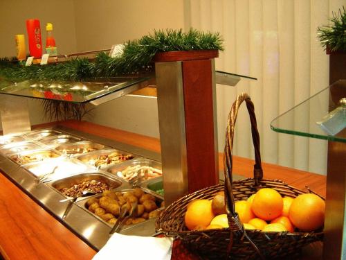 un buffet con una cesta de naranjas y otros alimentos en Finlandia Hotel, en Pamporovo