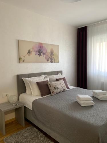 a bedroom with a large bed with pillows at Kraljev Park sa parking mestom in Novi Sad