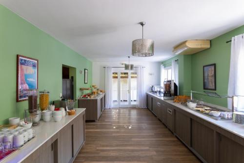 Hotel U Ricordu & Spa في ماسيناغو: مطبخ كبير بجدران خضراء وعدادات خشبية