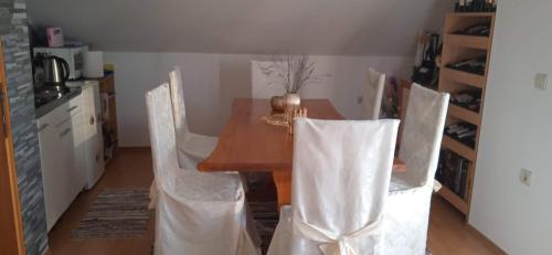 a dining room with a table and white chairs at Nika in Ogulin
