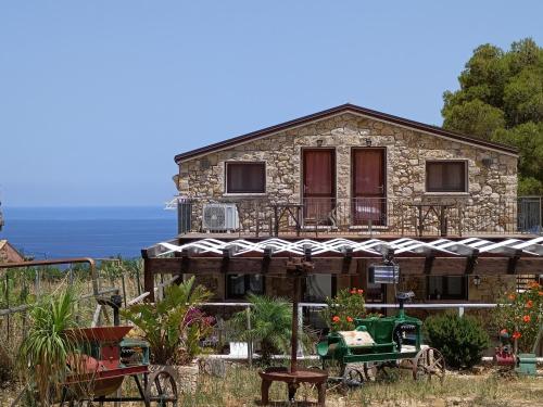 a stone house with a green tractor in front of it at Casolare La Torre in Scopello