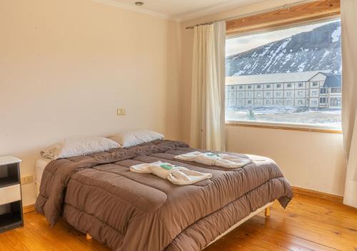 a bedroom with a bed and a large window at Hotel Nuke Piren in Caviahue