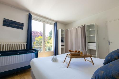 Un dormitorio con una cama y un televisor y una ventana. en Villa Palmera, en Saint-Aignan