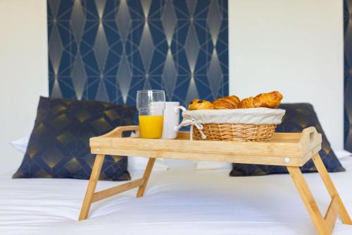 - une table avec un panier de pain et un verre de jus d'orange dans l'établissement Villa Palmera, à Saint-Aignan