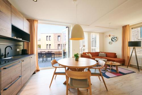 a kitchen and living room with a table and chairs at Dormio Resort Maastricht Castellum Apartments in Maastricht