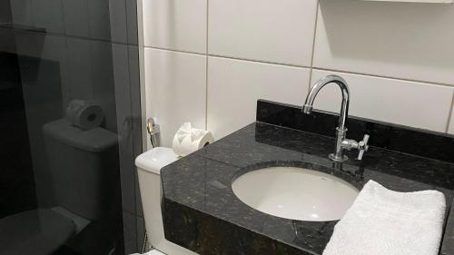 a bathroom with a sink and a toilet at Pousada Santa Inês in Cachoeira Paulista