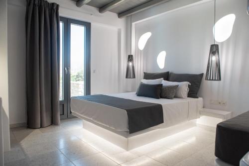 a white bedroom with a large bed and a window at Passa Corda Suites with amazing view in Galanado