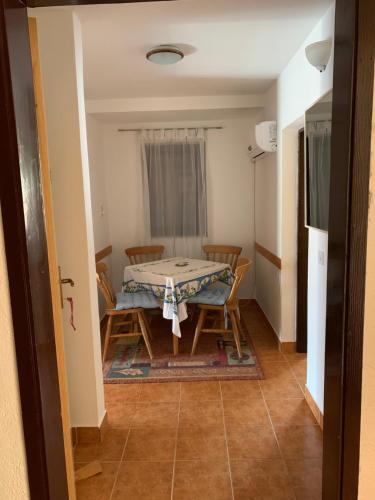 a dining room with a table and chairs in a room at Apartment Aida in Karlobag