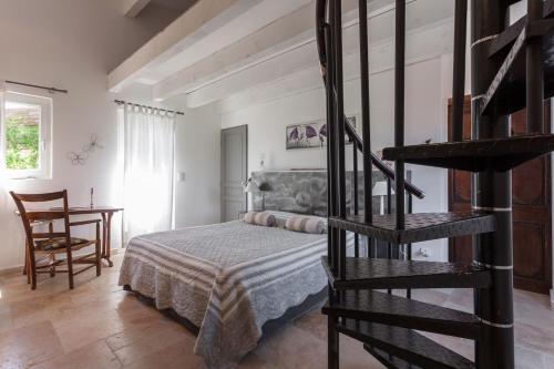 1 dormitorio con 1 cama y escalera de caracol en Mas Nina Rosa, en Mazan