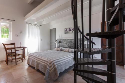 a bedroom with a bed and a spiral staircase at Mas Nina Rosa in Mazan