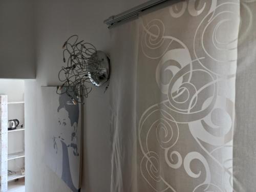 a shower curtain with a swirl pattern on a wall at Casetta Iacono camera Pithecusa in Ischia