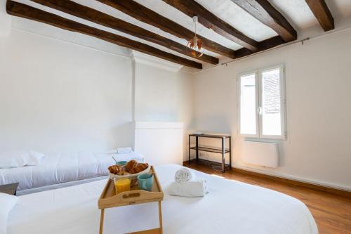 een witte kamer met een bed en een bank bij Perruche in Saint-Aignan