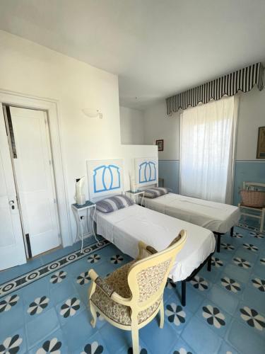 a bedroom with two beds and a chair in it at Le Stanze del Monsignore in Novoli