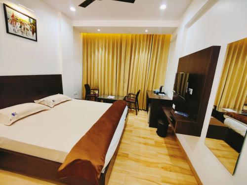 a bedroom with a bed and a desk and a room at Shivanand Residency in Jejūri