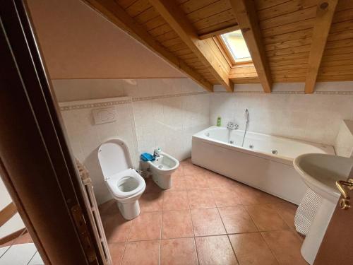 a bathroom with a toilet and a tub and a sink at Casavacanze IL GALLO in Omegna