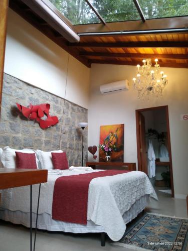 a bedroom with a bed with a red teddy bear on the wall at Espaço Viverde Penedo in Penedo
