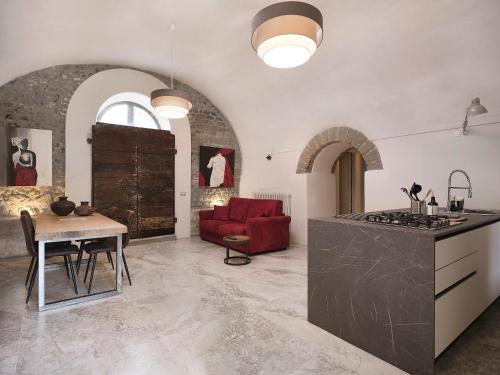 a kitchen and living room with a table and a red couch at Agriturismo Castello Santa Margherita in Cori