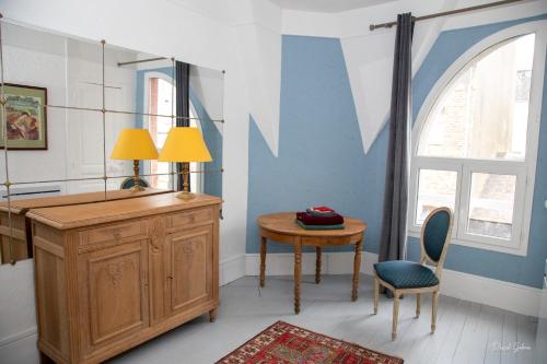 Cette chambre comprend un bureau, une table et une fenêtre. dans l'établissement Villa la Rafale Belle époque, , parking gratuit plage 5mn, au Tréport