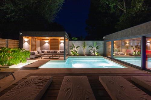 a swimming pool in a backyard at night at DV Premium Apartments in Siófok