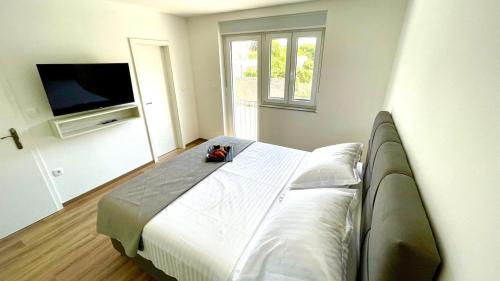 a bedroom with a bed and a flat screen tv at Studio Apartmani Kaja i Iva in Sinj
