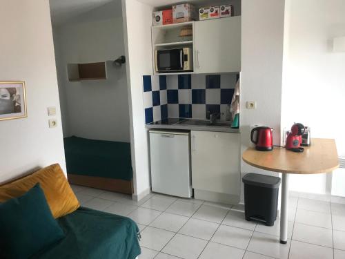 une petite cuisine avec un canapé et une table dans l'établissement Studio Cap d'Agde avec piscine proche de la mer, au Cap d'Agde