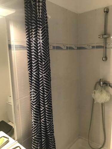 une douche avec rideau de douche noir et blanc dans l'établissement Studio Cap d'Agde avec piscine proche de la mer, au Cap d'Agde