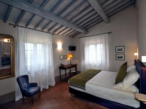 een slaapkamer met een bed, een bureau en een stoel bij Villa le buche in Sarteano